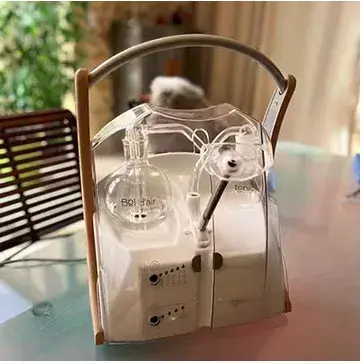 L'appareil Bol d'Air Jacquier posé sur une table, sa corolle de verre et sa poignée en bois