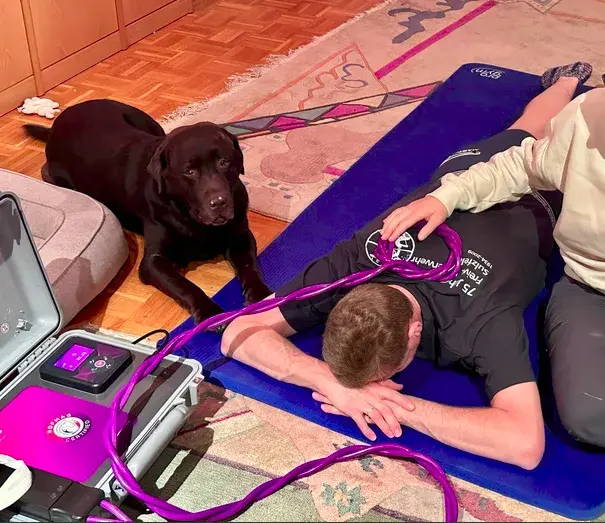 Séance HOFMAG sur un tapis, la boucle posée dans le dos, un chien allongé à côté