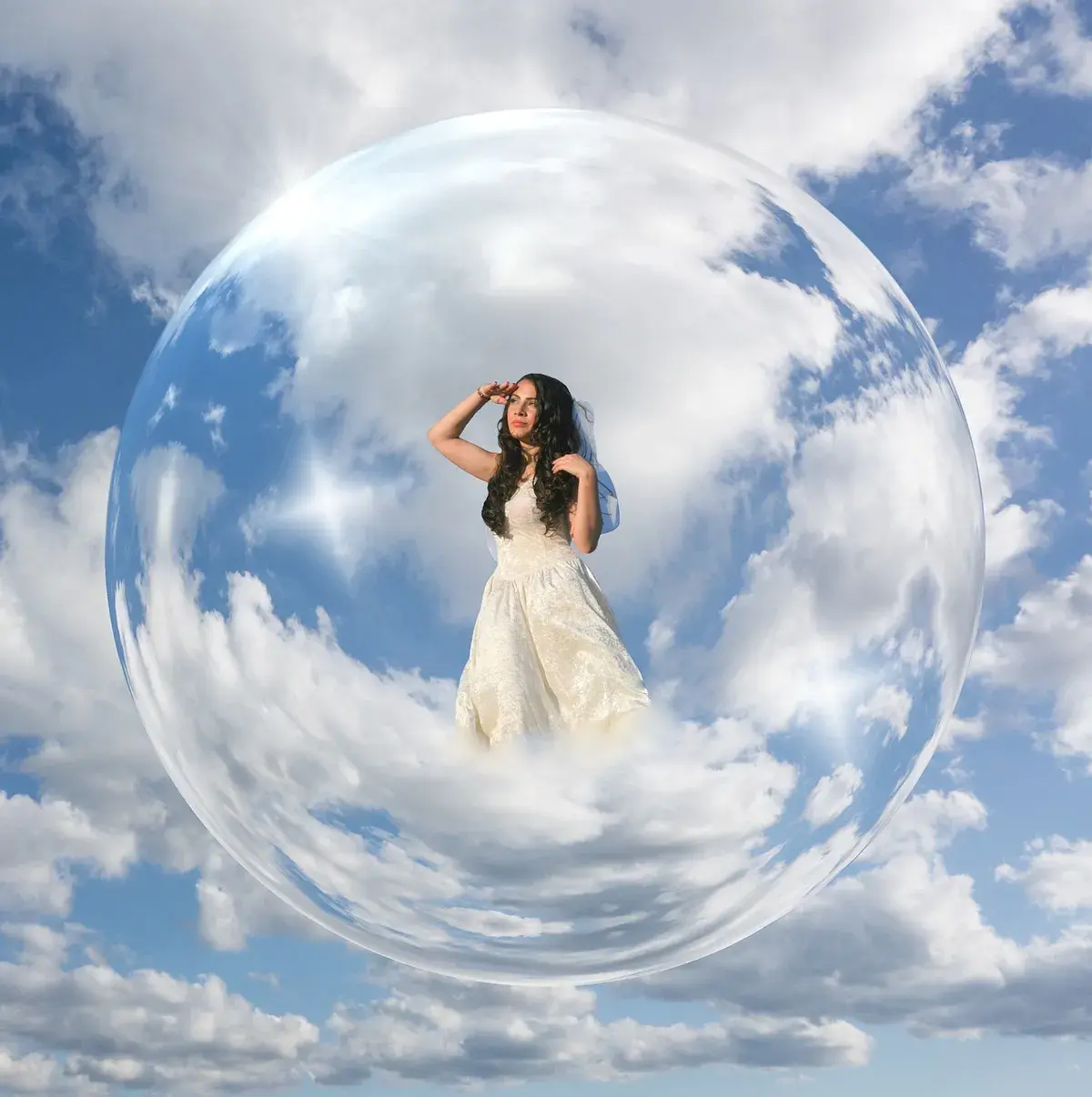 Une femme en robe blanche à l'intérieur d'une grande bulle, dans le ciel